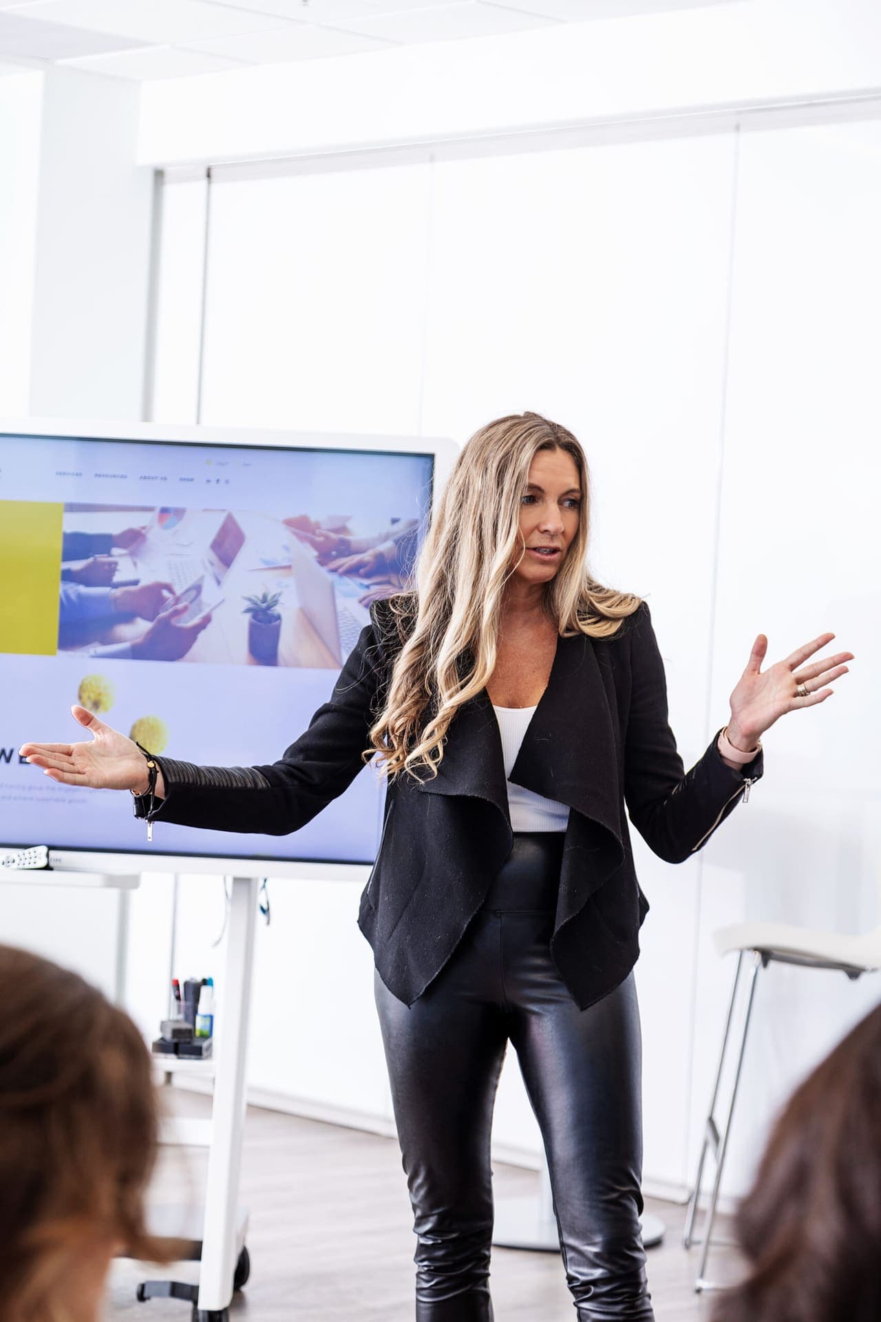 A facilitator gesturing to a presentation screen during a Level Up workshop.
