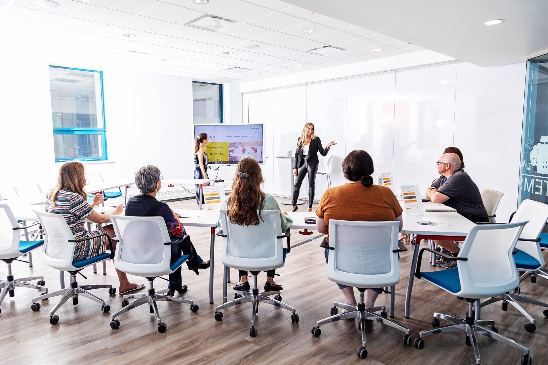 Leaders seated around tables in a bright room during a Level Up session.